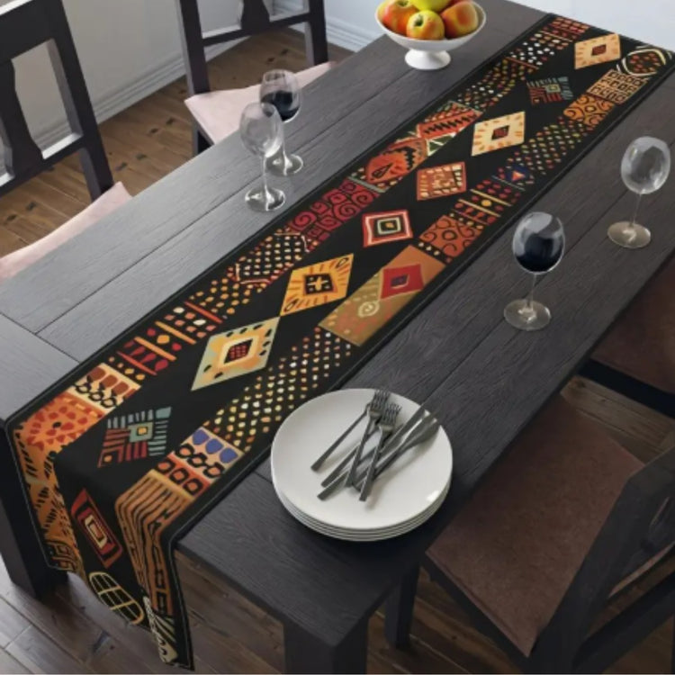 Dark table runner with orange and gold geometric motifs and decorative patterned bands.