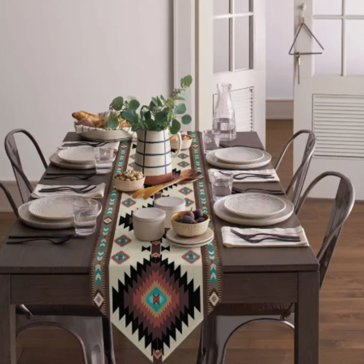 Cream table runner with bold turquoise and rust diamonds on a set dining table.