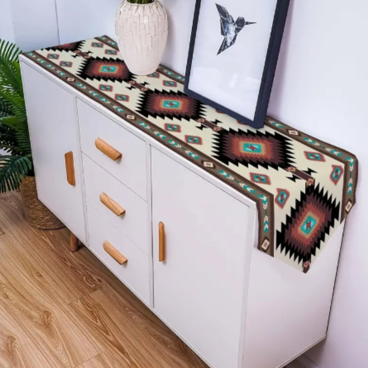 Turquoise and rust geometric table runner displayed along a white sideboard.