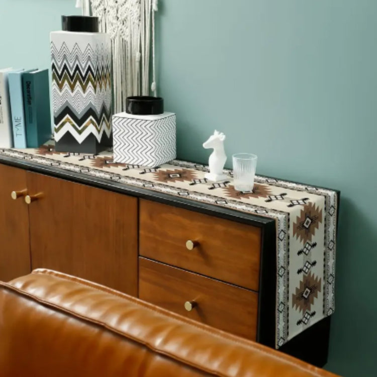 Cream and brown geometric table runner displayed on a wooden sideboard.