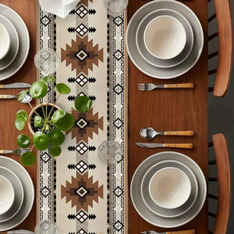 Overhead view of a brown and cream geometric table runner between place settings.