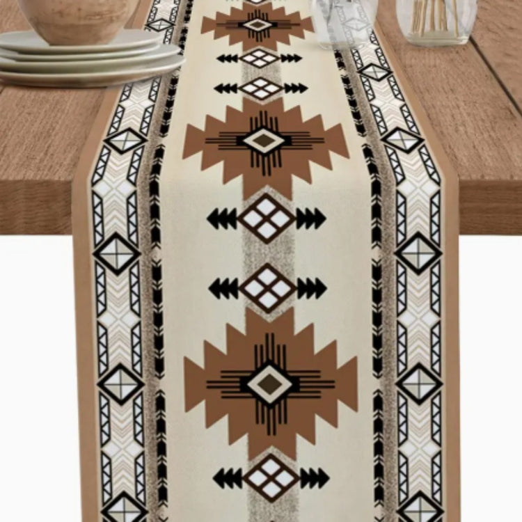 Close view of a cream table runner with brown stars and black geometric borders.