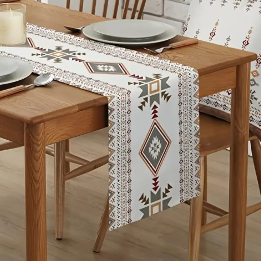 Cream table runner with brown and grey diamond motifs draped over a table.