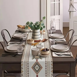 Cream table runner with muted geometric motifs on a set dining table.