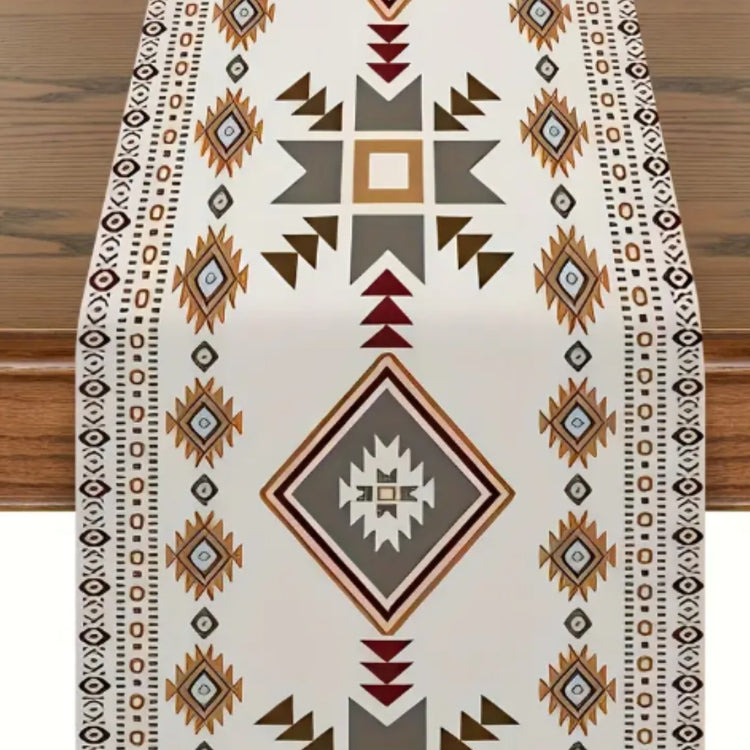 Overhead view of a cream geometric table runner with brown, grey and burgundy accents.