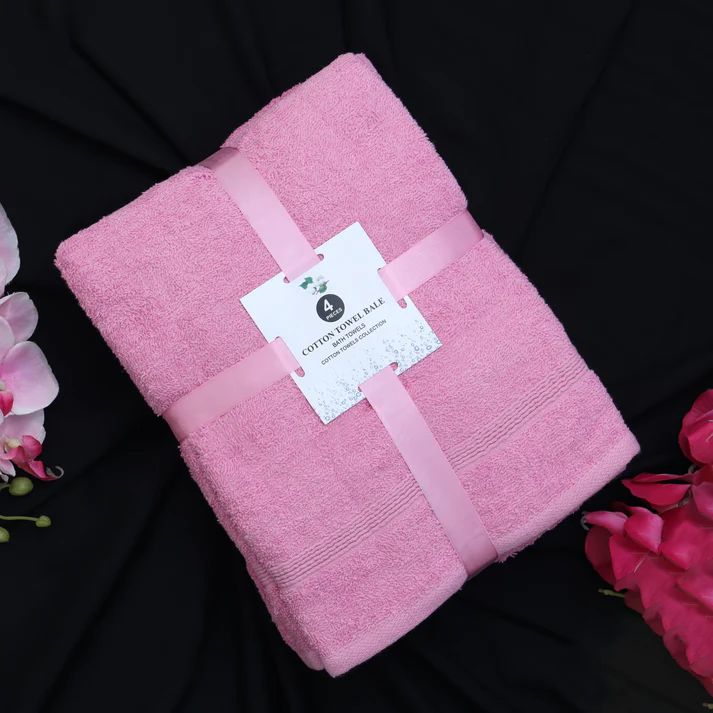 Folded pink cotton towel set tied with a ribbon.