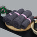 Charcoal grey cotton towels rolled and arranged on a tray.