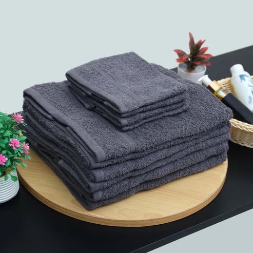 Charcoal grey bath towels and smaller towels stacked together.