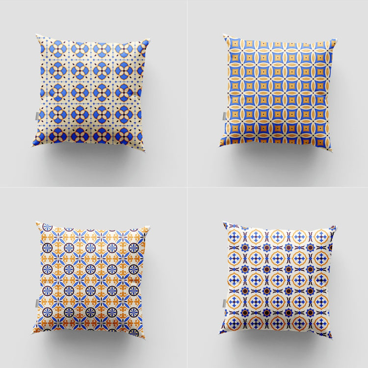 Four blue, yellow and white cushion covers with repeating tile-like geometric patterns.