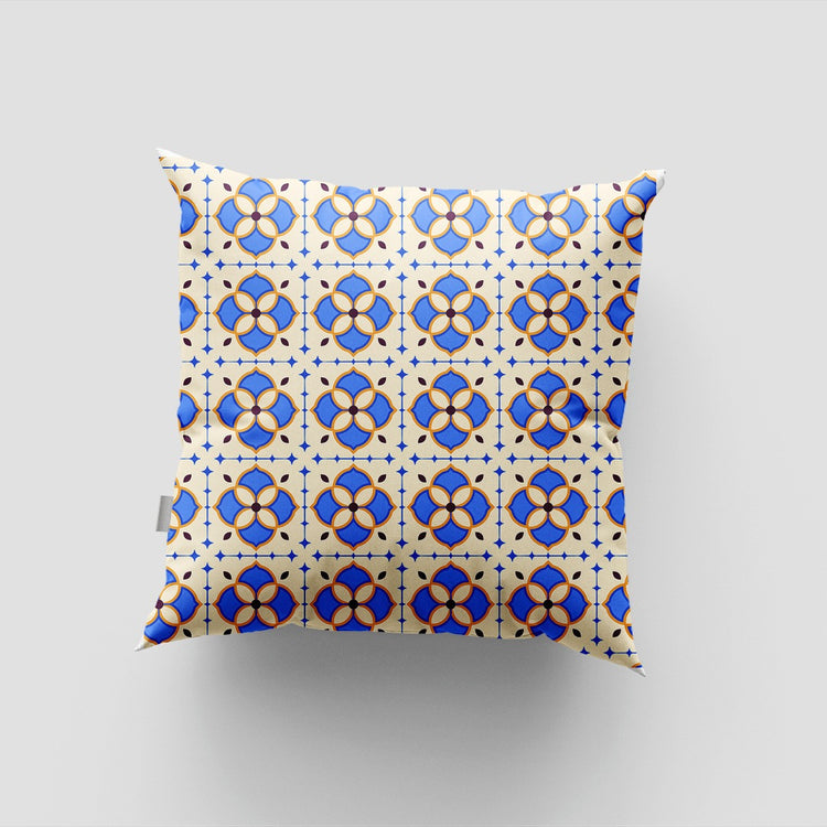 Cushion cover with small blue and yellow floral tile motifs on white.