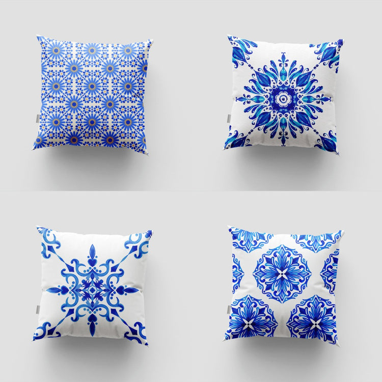 Four blue and white cushion covers with ornate floral and tile patterns.