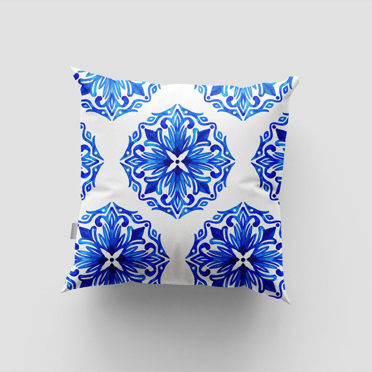 White cushion cover with large blue circular floral medallions.