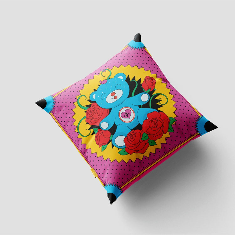Turquoise cushion cover with a colourful central face and floral motifs.