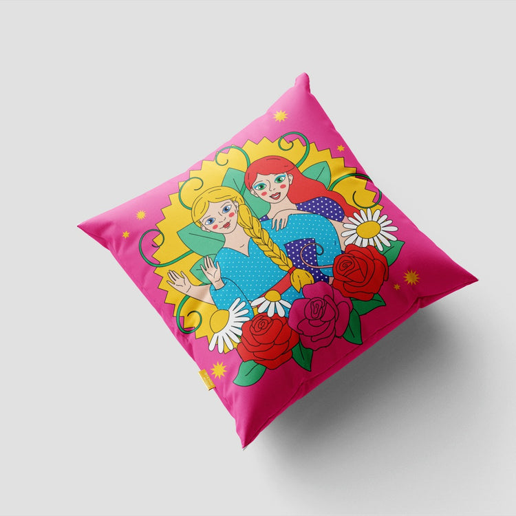 Pink cushion cover with colourful portrait illustrations inside a floral frame.