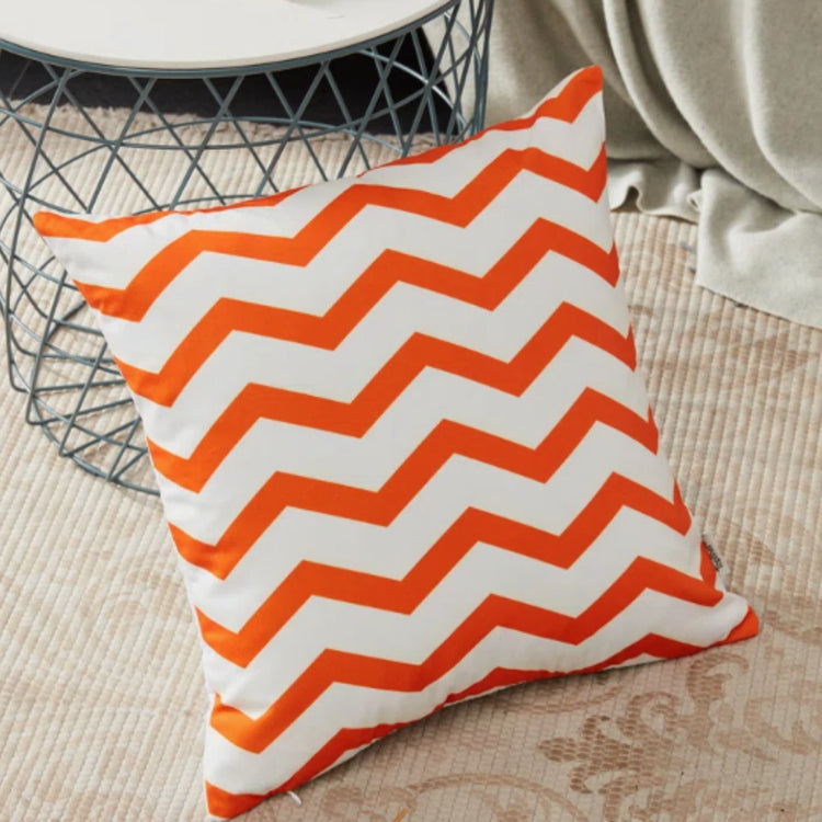 White cushion cover with bold orange zigzag stripes.