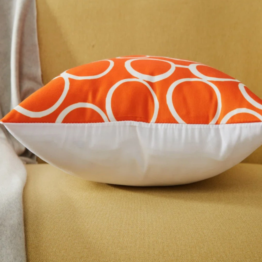 Side view of an orange and white circle-pattern cushion cover showing the white reverse.