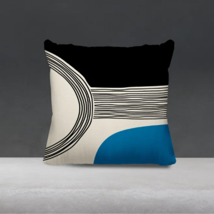 Black and cream cushion cover with fine curved lines and a blue lower corner.