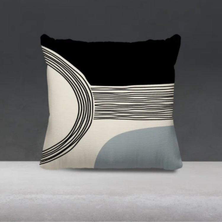 Black and cream cushion cover with fine curved lines and a pale blue lower corner.