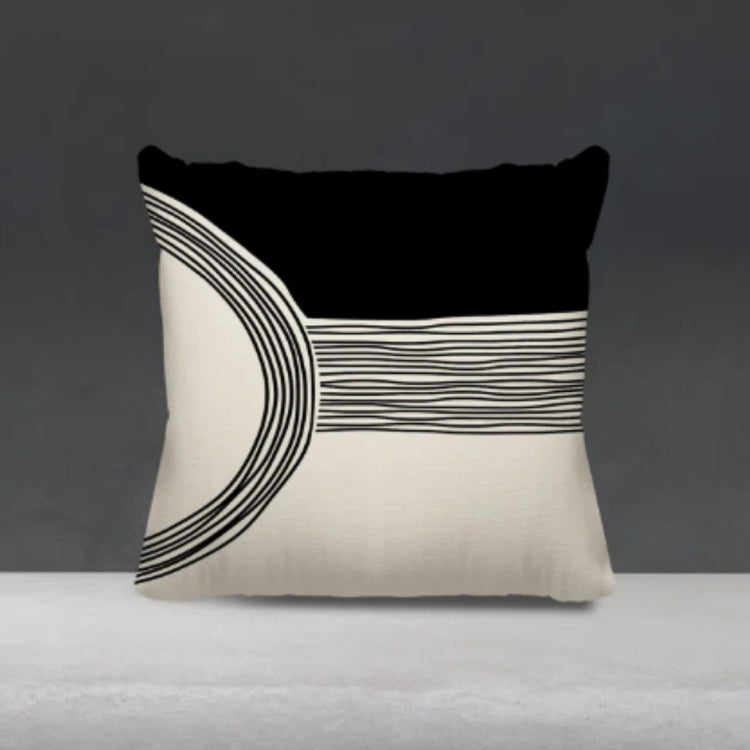Black and cream cushion cover with fine curved lines across a cream lower panel.