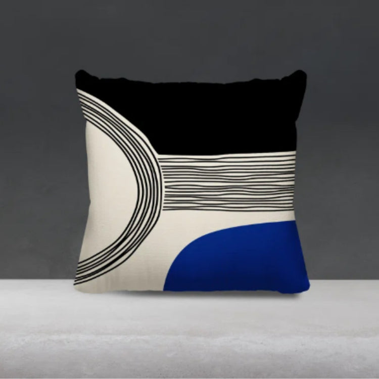 Black and cream cushion cover with fine curved lines and a deep blue lower corner.