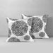 Two white cushion covers with black circular floral patterns.