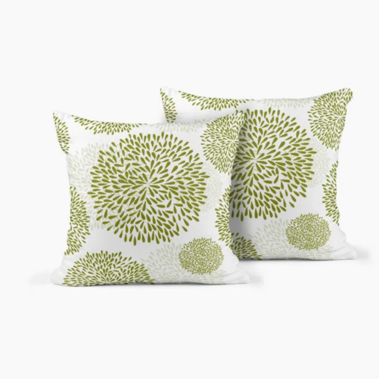 Two white cushion covers with light green circular floral patterns.