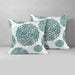 Two white cushion covers with sage green circular floral patterns.