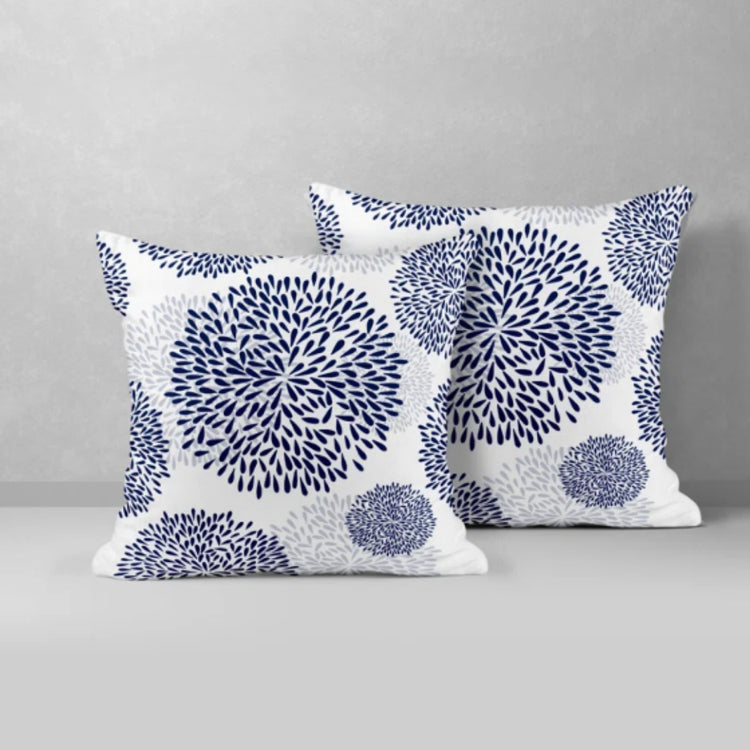 Two white cushion covers with navy circular floral patterns.