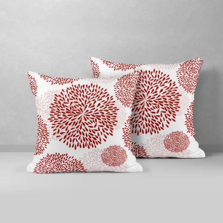 Two white cushion covers with muted red circular floral patterns.
