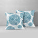 Two white cushion covers with teal circular floral patterns.