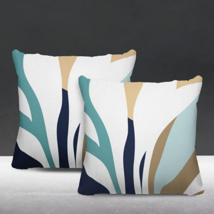 Two cream cushion covers with teal, navy and beige abstract leaf-like shapes.
