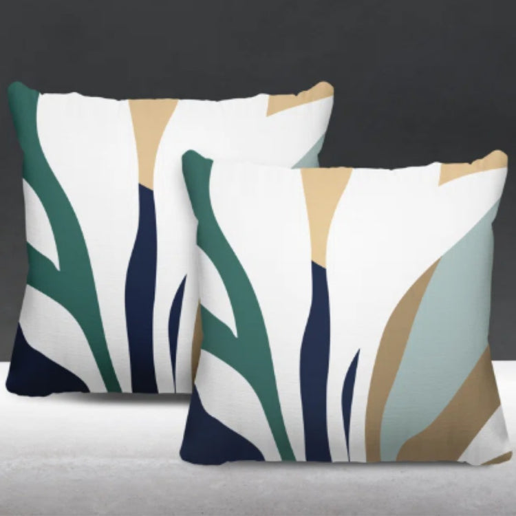 Two cream cushion covers with dark green, navy and beige abstract leaf-like shapes.