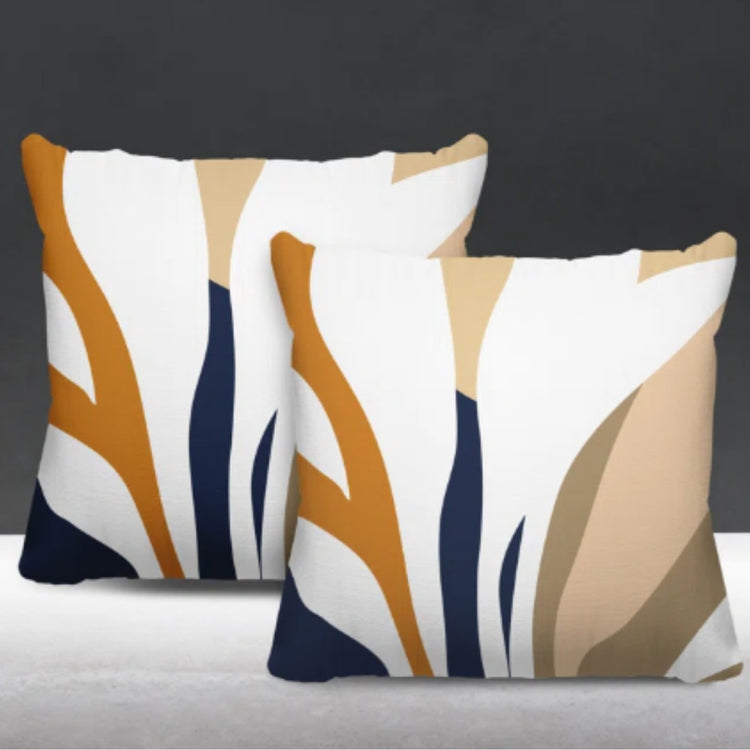 Two cream cushion covers with orange, navy and beige abstract leaf-like shapes.