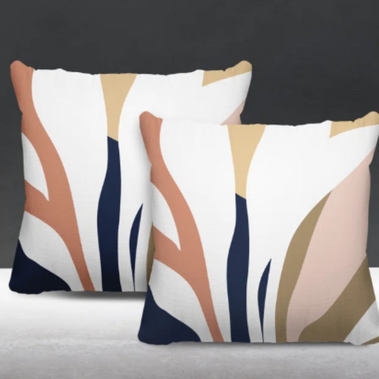 Two cream cushion covers with rust, pink, navy and beige abstract leaf-like shapes.