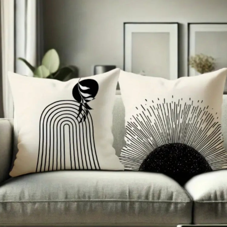 Close view of cream cushion covers with a black lined arch and a radial sunburst.