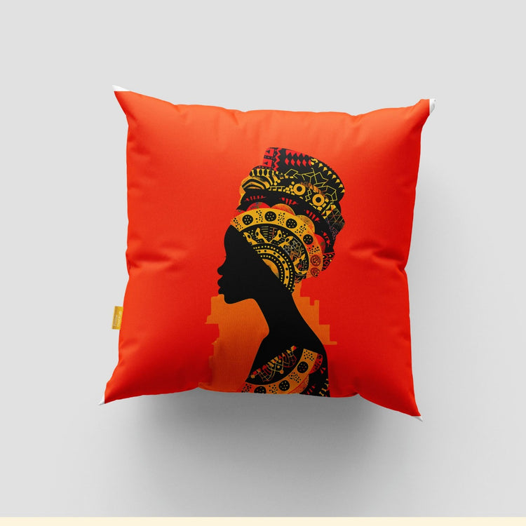 Orange cushion cover with a black profile silhouette and colourful patterned headwrap.