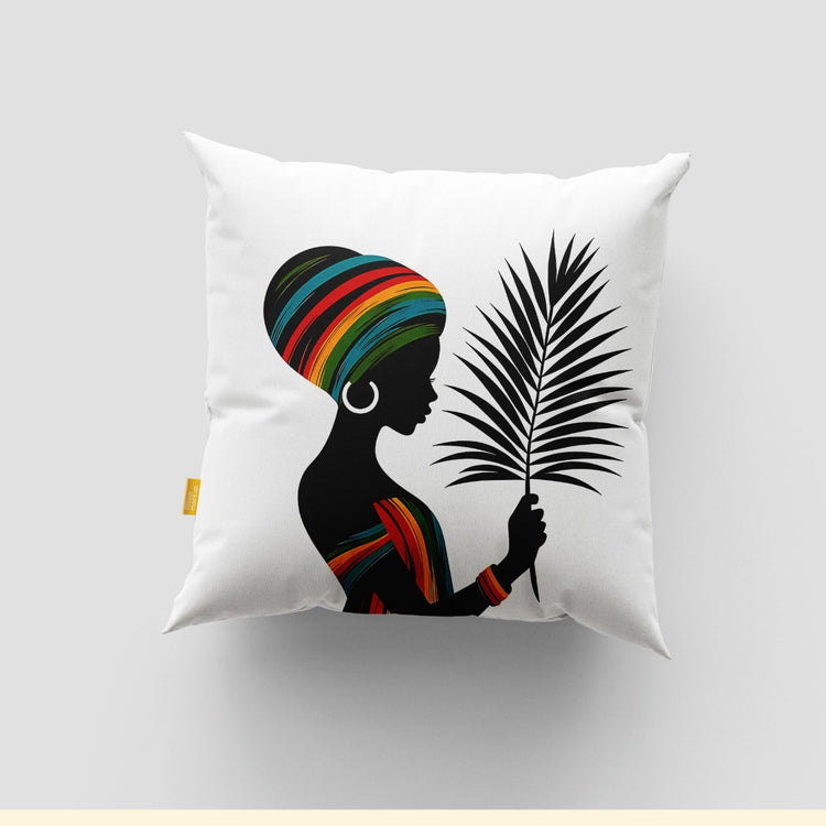 White cushion cover with a woman in a colourful headwrap holding a black palm frond.