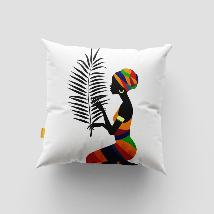 White cushion cover with a seated woman in colourful clothing beside a black palm frond.