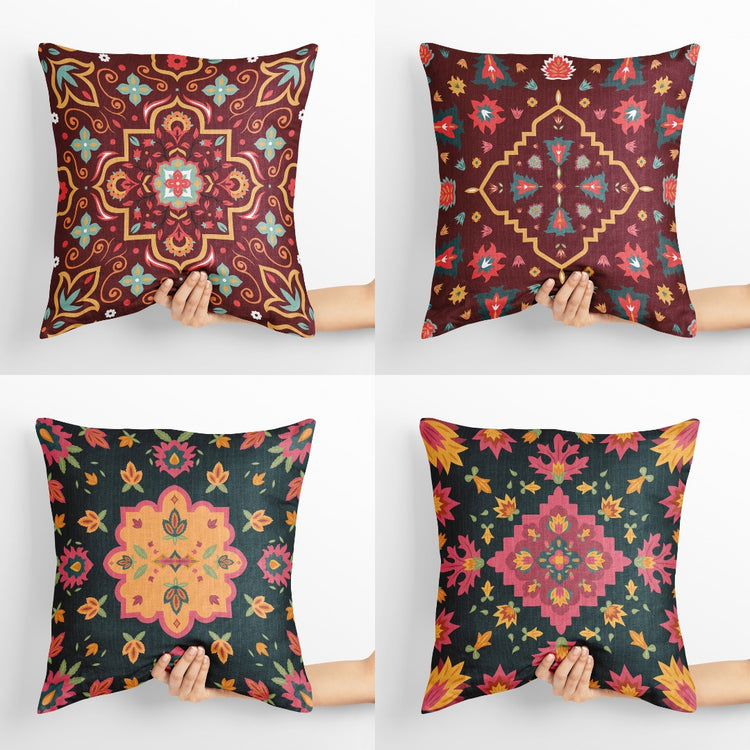 Four dark cushion covers with colourful floral medallion patterns.