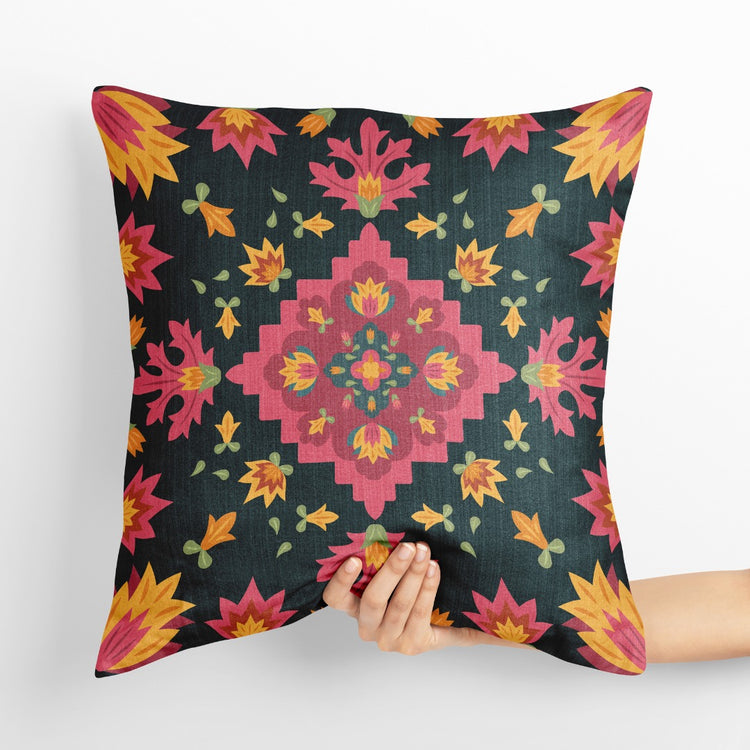 Dark cushion cover with a pink and orange diamond-shaped floral medallion.
