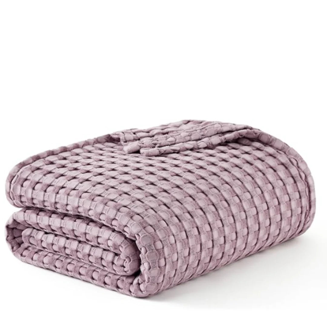 Folded lilac waffle-weave blanket on a white background.
