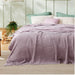 Lilac waffle-weave blanket spread across a bed.