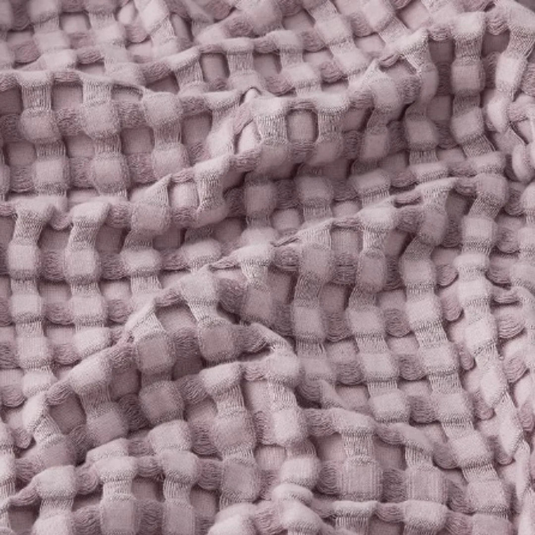 Close-up of lilac waffle-weave blanket texture.
