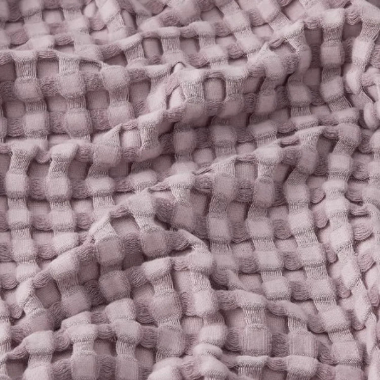 Close-up of lilac waffle-weave blanket texture.