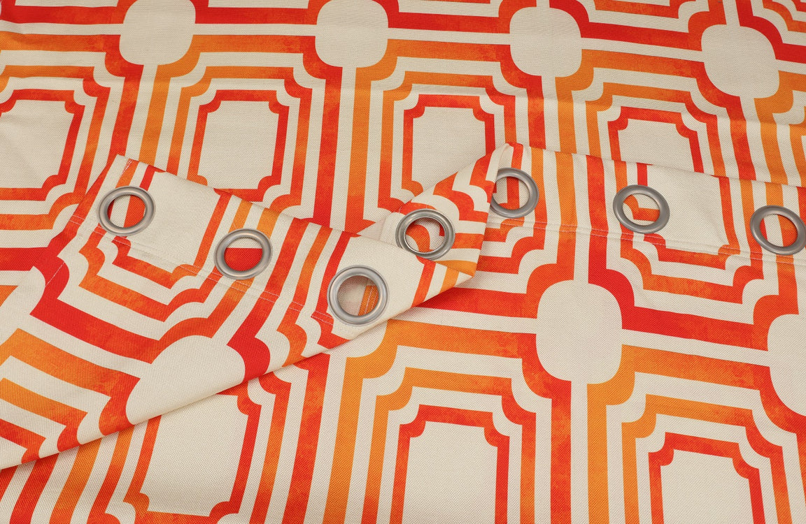 Close-up of orange and cream geometric curtain fabric and metal eyelets.