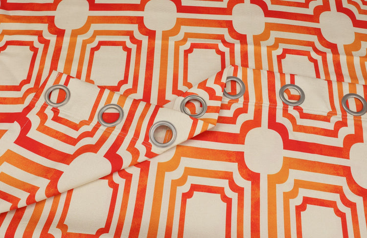 Close-up of orange and cream geometric curtain fabric and metal eyelets.