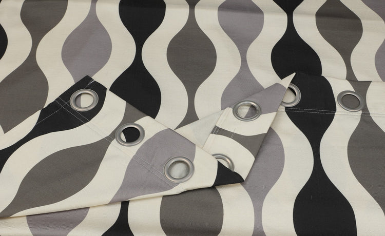 Close-up of black and grey wavy curtain fabric and metal eyelets.