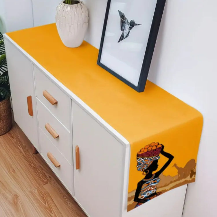Yellow illustrated table runner displayed along a white sideboard.