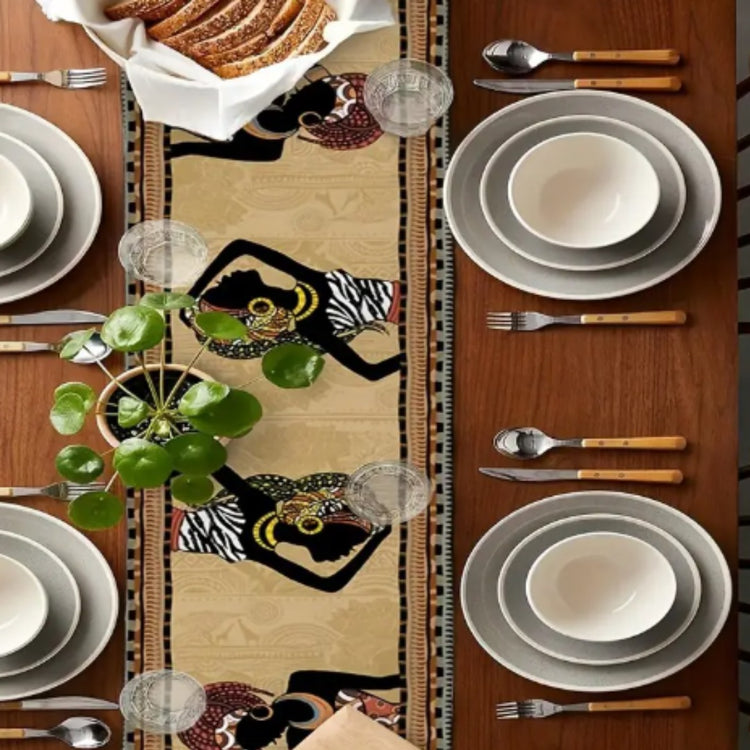 Overhead view of a beige portrait-pattern table runner between place settings.