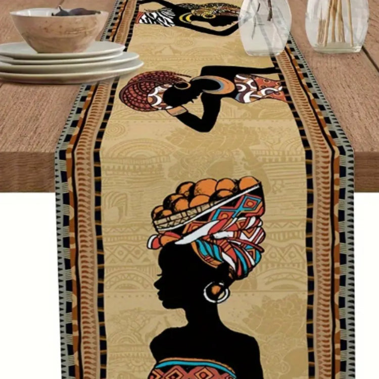 Close-up of colourful headwrap portraits and borders on a beige table runner.